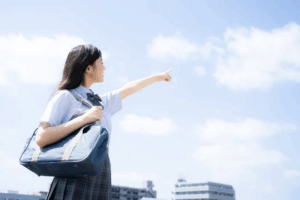 ARK英会話教室 女子高生が目標に向かって空に指をさしている